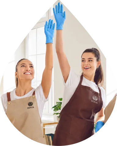 Due addette alle pulizie professionali al lavoro su una superficie in vetro